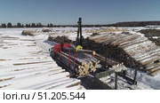 aerial photography of unloading logs from a car trailer using a manipulator. Стоковое видео, видеограф Алексей Сергеев / Фотобанк Лори
