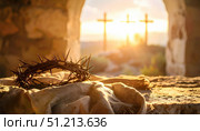 Crown of thorns resting on cloth with crosses in sunlight symbolizing sacrifice redemption faith and Easter traditions tied to hope and resilience in Christian culture. Стоковое AI-изображение, AI-художник Ольга Сухарева / Фотобанк Лори
