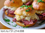 Savory Sandwiches Loaded with Tender Meat, Sauerkraut, and Fresh Herbs on Soft Buns Perfect for Any Gathering or Solo Indulgence. Стоковое AI-изображение, AI-художник Башкирова Анна / Фотобанк Лори