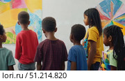 A group of children engaged in meaningful discussions as they admire vibrant artwork at a local art gallery during their school trip. Стоковое AI-видео, аниматор Данила Большаков / Фотобанк Лори