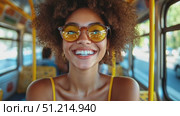 A joyful young woman with curly hair and stylish sunglasses rides the bus, sharing her infectious smile and positivity on a summer afternoon. Стоковое AI-видео, аниматор Данила Большаков / Фотобанк Лори