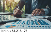 A person reviews detailed charts and graphs while planning financial strategies, accompanied by a laptop in a peaceful outdoor environment. Стоковое AI-видео, аниматор Данила Большаков / Фотобанк Лори