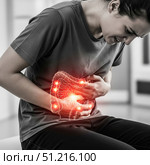 Woman suffering from severe stomach ache with red glowing intestines illustration, person having digestive problems, abdominal pain or period cramps concept. Стоковое AI-изображение, AI-художник Павел Муравьев / Фотобанк Лори