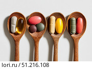 Different soft gels, Fish oil, capsules omega 3, vitamin pills tablets food supplements in wooden spoon. Spoonful of medicine, vitamins set. Variety of supplemental and healthcare product, flat lay. Стоковое AI-изображение, AI-художник Марина Демидюк / Фотобанк Лори
