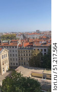 View of red-roofed buildings and river with distant cityscape under clear blue sky. Стоковое видео, видеограф Анастасия Золотницкая / Фотобанк Лори