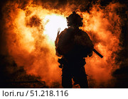 Silhouette of a soldier standing amongst smoke, armed with an assault rifle. Oleg Zabielin / Stocktrek Images/TASS. Стоковое фото, агентство ТАСС / Фотобанк Лори