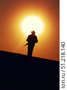 Silhouette of a soldier patrolling an area at sunset. Oleg Zabielin / Stocktrek Images/TASS. Стоковое фото, агентство ТАСС / Фотобанк Лори