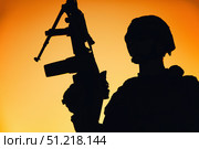 Silhouette of a soldier holding weapon at dawn. Oleg Zabielin / Stocktrek Images/TASS. Стоковое фото, агентство ТАСС / Фотобанк Лори