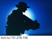 Silhouette of a soldier with bullpup submachine gun on background of setting sun. Oleg Zabielin / Stocktrek Images/TASS. Стоковое фото, агентство ТАСС / Фотобанк Лори