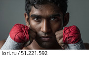 Muscular boxer with red wrapped hands, sweat glistening, standing in intense pre fight stance during competitive training session. Стоковое AI-изображение, AI-художник Юрий Поздников / Фотобанк Лори