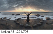 Ocean waves crash on the shore as a woman stands inside a stone circle on a beach, raising her arms towards the setting sun in a ritualistic pose. Стоковое AI-видео, аниматор Юрий Поздников / Фотобанк Лори