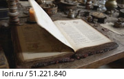 Weathered grimoire pages revealing arcane symbols, illuminated by candlelight near scattered alchemical instruments on aged wooden surface, mystical knowledge unfolding. Стоковое AI-видео, аниматор Юрий Поздников / Фотобанк Лори