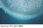 Spherical ice melting underwater, releasing intricate bubbles, transforming against deep blue liquid environment. Стоковое AI-видео, аниматор Юрий Поздников / Фотобанк Лори