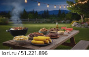 Sizzling barbecue grilling on wooden table, soft string lights illuminating cozy backyard gathering with warm summer evening ambiance. Стоковое AI-видео, аниматор Юрий Поздников / Фотобанк Лори