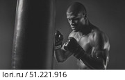 Black muscular boxer throwing powerful punches on heavy bag, monochrome image highlighting intense training, physical strength, and athletic determination. Стоковое AI-видео, аниматор Юрий Поздников / Фотобанк Лори