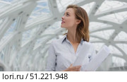 Professional architect analyzing blueprints near glass walls, focused on urban design project within contemporary workspace, showcasing expertise and strategic planning skills. Стоковое AI-видео, аниматор Юрий Поздников / Фотобанк Лори