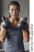 Athletic asian woman lifting kettlebell, demonstrating strength and fitness commitment during intense workout in modern gym setting. Стоковое AI-видео, аниматор Юрий Поздников / Фотобанк Лори