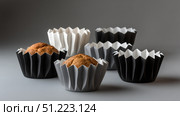 Minimalist cupcakes in monochrome wrappers, spaced out, soft background. Стоковое AI-изображение, AI-художник ALLA YURTAYEVA / Фотобанк Лори