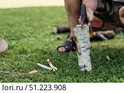 The axe is in the man's hand and is stuck in a birch log. Preparing firewood for the winter season. Logging. Timber, tools for cutting wood. Стоковое фото, фотограф Photojuli / Фотобанк Лори
