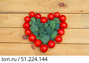 Heart healthy vegetables concept. Ripe red tomatoes in heart shape and green broccoli cabbage on wooden garden table. Organic farm products. Flat lay, close-up, top view, copy space. Стоковое фото, фотограф Виктория Катьянова / Фотобанк Лори