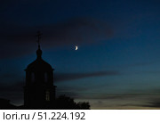 Blue summer night sky, crescent moon and dark silhouette of Orthodox church with cross, copy space. Стоковое фото, фотограф irisff / Фотобанк Лори