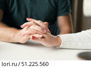Couple holding hands at home. Happy Man and Woman. Two Loving Hands Together on the Couch Sharing Deep Affection and Love in Details. Intimate connection. Close-up of Intertwined female and male hands. Стоковое фото, фотограф Марина Демидюк / Фотобанк Лори