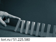 Domino has Fallen in a Row. Domino theory. Effect. Hand with Finger is Pointing and Pushing the Falling Wood Blocks. Risk Management, Revolution Concept. Affect Business. Closeup. Manifestation. Red. Стоковое фото, фотограф Марина Демидюк / Фотобанк Лори