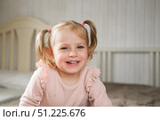 Little Girl joking sticking tongue out with silly expression. Child making face. Funny foolishness portrait of baby girl laughing in bedroom. Adorable Caucasian kid doing crazy comical gesture at home. Стоковое фото, фотограф Марина Демидюк / Фотобанк Лори