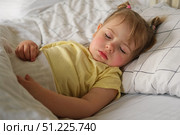 Peaceful adorable baby sleeping on a bed at home. Slumbering little child. Two years old girl sleeps peaceful at domestic room interior background. Serene dream. Cute face close up. Deep kid slumber. Стоковое фото, фотограф Марина Демидюк / Фотобанк Лори