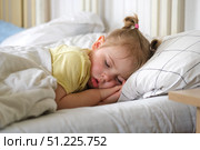 Peaceful adorable baby sleeping on a bed at home. Slumbering little child. Two years old girl sleeps peaceful at domestic room interior background. Serene dream. Cute face close up. Deep kid slumber. Стоковое фото, фотограф Марина Демидюк / Фотобанк Лори