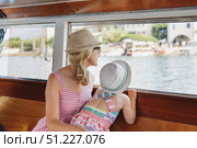 Mother and daughter look out at Lake Maggiore through a window and sail to Isola Bella. Стоковое фото, фотограф Irina Kuchugurina/Gaudy / Фотобанк Лори