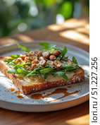 Delicious Open-Faced Sandwich Topped With Fresh Greens and Nuts Served on a Wooden Table. Стоковое AI-изображение, AI-художник Юлия Гапеенко / Фотобанк Лори