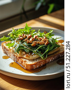 Delicious Open-Faced Sandwich Topped With Greens and Nuts on a Wooden Table in Natural Light. Стоковое AI-изображение, AI-художник Юлия Гапеенко / Фотобанк Лори
