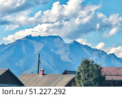 Mountain views from the residential population. Sayan Mountains with cloud caps. Стоковое фото, фотограф Жанна Гапанович / Фотобанк Лори