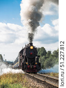 An old Soviet steam locomotive of the L series. The Ruskeala Express retro train is on its way to the mountain park. Thick smoke is coming from the chimney. Russia, Republic of Karelia, Sortavala, August 10, 2025. Редакционное фото, фотограф Photojuli / Фотобанк Лори