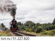 An old Soviet steam locomotive of the L series. The Ruskeala Express retro train is on its way to the mountain park. Thick smoke is coming from the chimney. Russia, Republic of Karelia, Sortavala, August 11, 2025. Редакционное фото, фотограф Photojuli / Фотобанк Лори