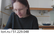 Woman peeling a lemon in the kitchen. Стоковое видео, видеограф Константин Шишкин / Фотобанк Лори