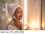 Serene self-care ritual of elderly black woman using facial roller in elegant setting. Стоковое AI-изображение, AI-художник Евгения Пархоменко / Фотобанк Лори
