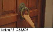 Woman knocking on rustic wooden door with antique metal ring. Стоковое видео, видеограф Ольга Сухарева / Фотобанк Лори