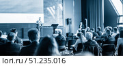 Speaker giving a talk in conference hall at business event. Business and entrepreneurship concept. Blue toned black and white image. Стоковое фото, фотограф Matej Kastelic / Фотобанк Лори