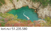 Tour boat navigating into turquoise cove surrounded by rocky cliffs in Capri. Стоковое видео, видеограф Ольга Сухарева / Фотобанк Лори