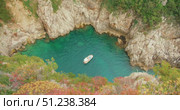 Boat floating in secluded turquoise cove with rocky walls during Capri tour. Стоковое видео, видеограф Ольга Сухарева / Фотобанк Лори