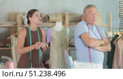 Young woman scolding elderly man in sewing workshop. Стоковое видео, видеограф Яков Филимонов / Фотобанк Лори