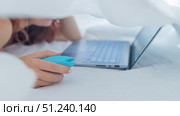 A woman lies in bed holding a clitoral vibrator and watching porn on a laptop. The girl has sex online. Стоковое фото, фотограф Михаил Решетников / Фотобанк Лори