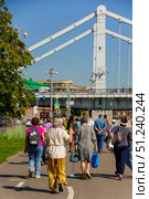 A group of people are walking down a street near a bridge.  Russia. Moscow. 24.08.25. Редакционное фото, фотограф Ярославский Максим / Фотобанк Лори