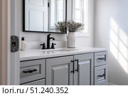 Grey bathroom vanity with white walls, mirror and marble countertop, black hardware. Clean aesthetic background. Home interior room design. Gray cabinet in a bathroom. Стоковое AI-изображение, AI-художник Марина Демидюк / Фотобанк Лори