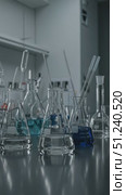 Laboratory glassware arranged on workbench with blue liquid samples. Стоковое AI-видео, аниматор KATERINA AI / Фотобанк Лори