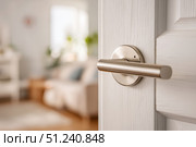 Doorknob. Metal door handle lock and latch of brass on veneer doors. Door wooden half opening through interior bedroom background, selective focus. Modern trends in interior design. Close-up. Стоковое AI-изображение, AI-художник Марина Демидюк / Фотобанк Лори