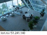 Modern Indoor Space Featuring Contemporary Furniture, Lush Plants, and Large Windows, Creating an Inviting and Open Atmosphere for Relaxation and Collaboration. Стоковое фото, фотограф Владимир Федоров / Фотобанк Лори