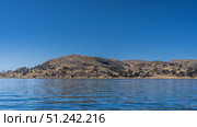 Beautiful blue lake. Ripples on the shiny calm water. There are rural houses and green trees on the coastal hills. Clear sky. Copy space. Lake Titicaca. Peru. Стоковое фото, фотограф Вера Ивановна Кубарева / Фотобанк Лори